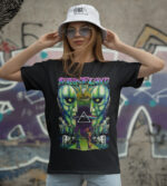 Renkli Pink Floyd tişört giyen kadın, sokak sanatı arka planında, stil sahibi ve retro tasarım odaklı, grunge ve rock tarzı giyim sevenler için uygun, modern ve dikkat çekici.