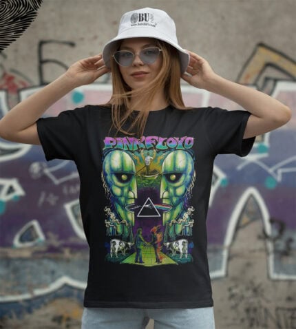 Renkli Pink Floyd tişört giyen kadın, sokak sanatı arka planında, stil sahibi ve retro tasarım odaklı, grunge ve rock tarzı giyim sevenler için uygun, modern ve dikkat çekici.