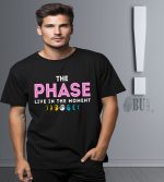 Yüksek kaliteli siyah Tişört üzerinde "The Phase, Live in the Moment" sloganı ve ay döngüsü tasarımı, stil ve anlamı bir araya getirerek gençler ve genç yetişkinler için ideal.